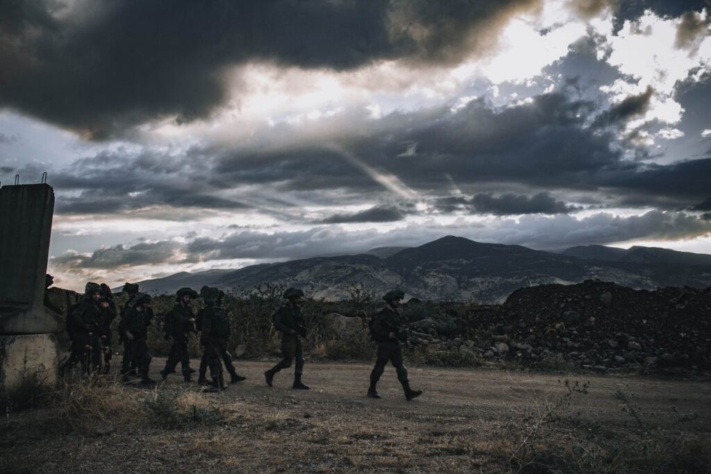 Israeli soldiers marching through rugged terrain