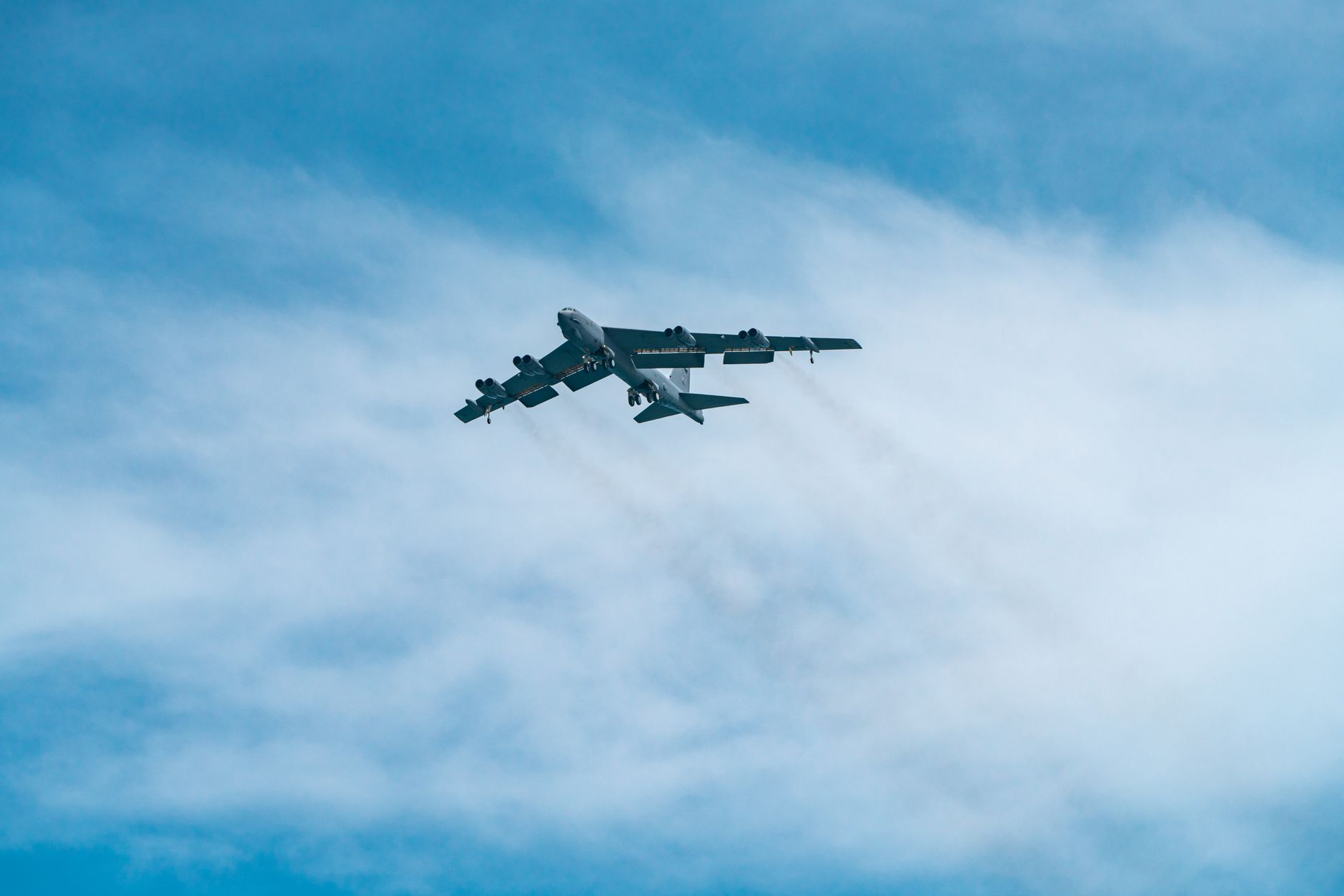 A B-52 Stratofortress bomber flying in a clear blue sky