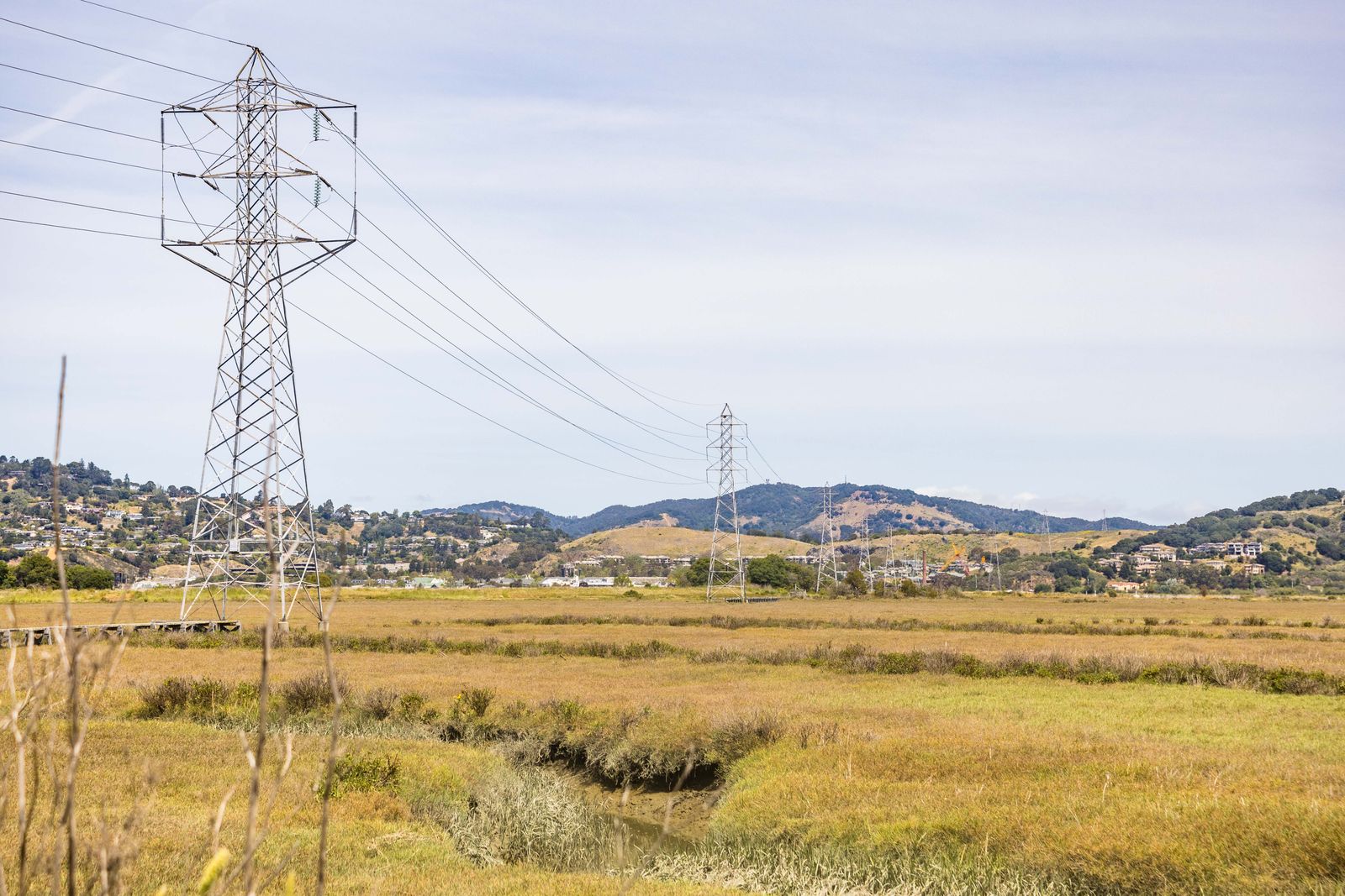 High-voltage electric transmission towers and power lines across an open landscape