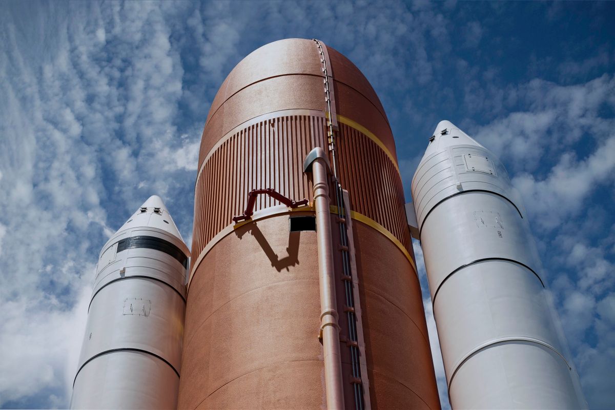 Rocket boosters ascending against a blue sky, evoking a ballistic missile launch