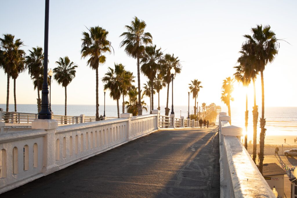 Palm trees lining a footbridge at sunset near Oceanside Pier on the Southern California coast