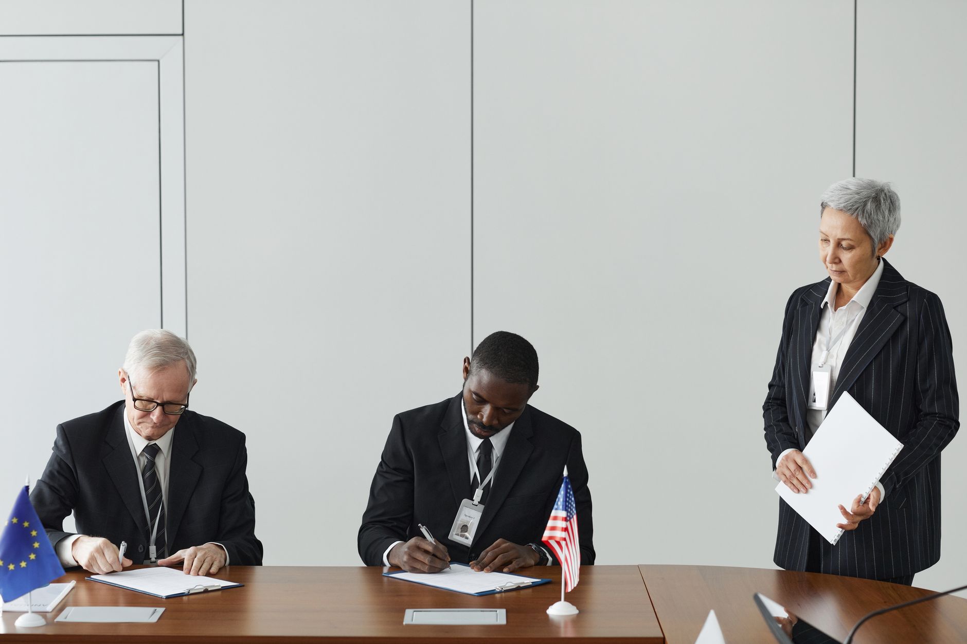 Officials signing an international agreement at a negotiating table