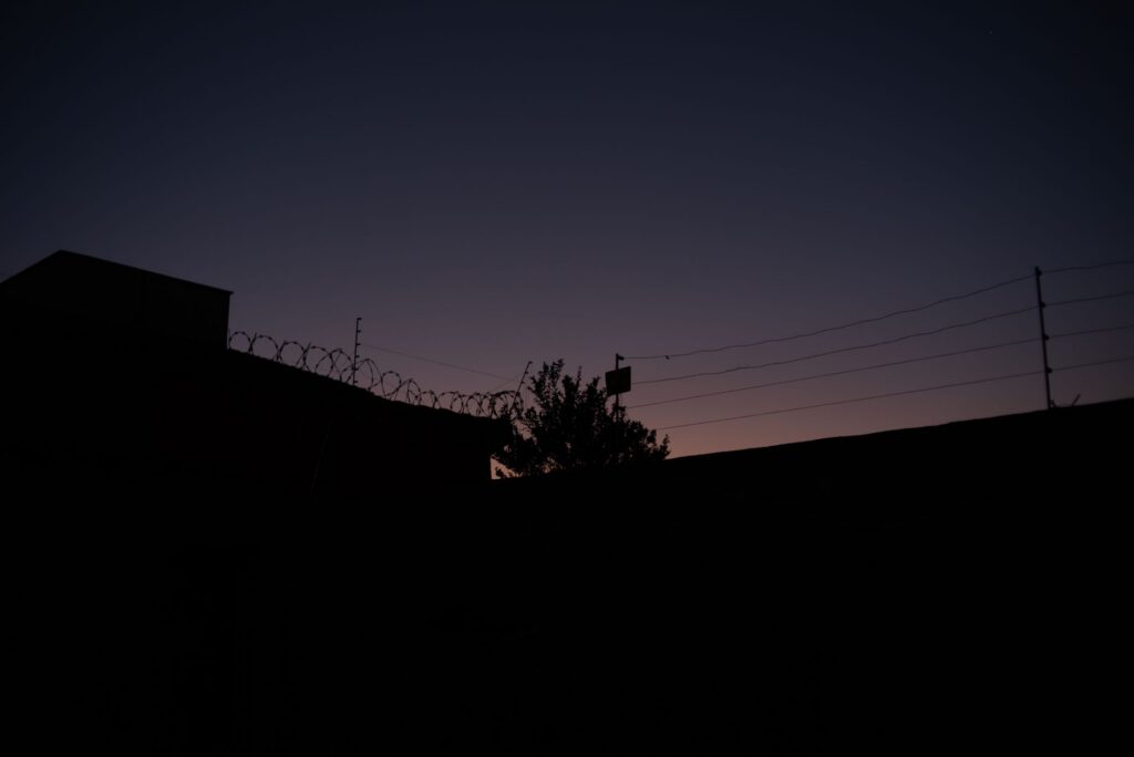Silhouette of a barbed wire fence against a dramatic sky